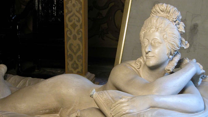 Life size off-white plaster sculpture of Giovanna Zanerini, 'La Baccelli' the dancer and mistress of the 3rd Duke of Dorset, reclining on drapery at Knole in Kent.